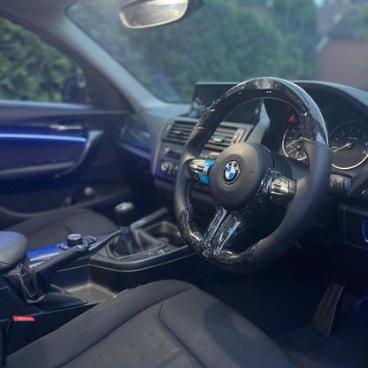 Car interior with steering wheel featuring BMW logo